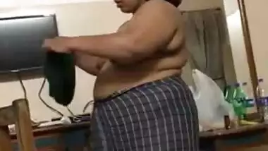 Fat Indian woman with big belly walks around the house with naked boobs